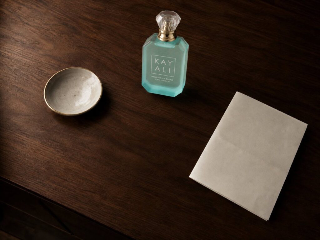 dark wood dresser surface after decluttering with only three intentional items — a ceramic dish, a perfume bottle, and a card
