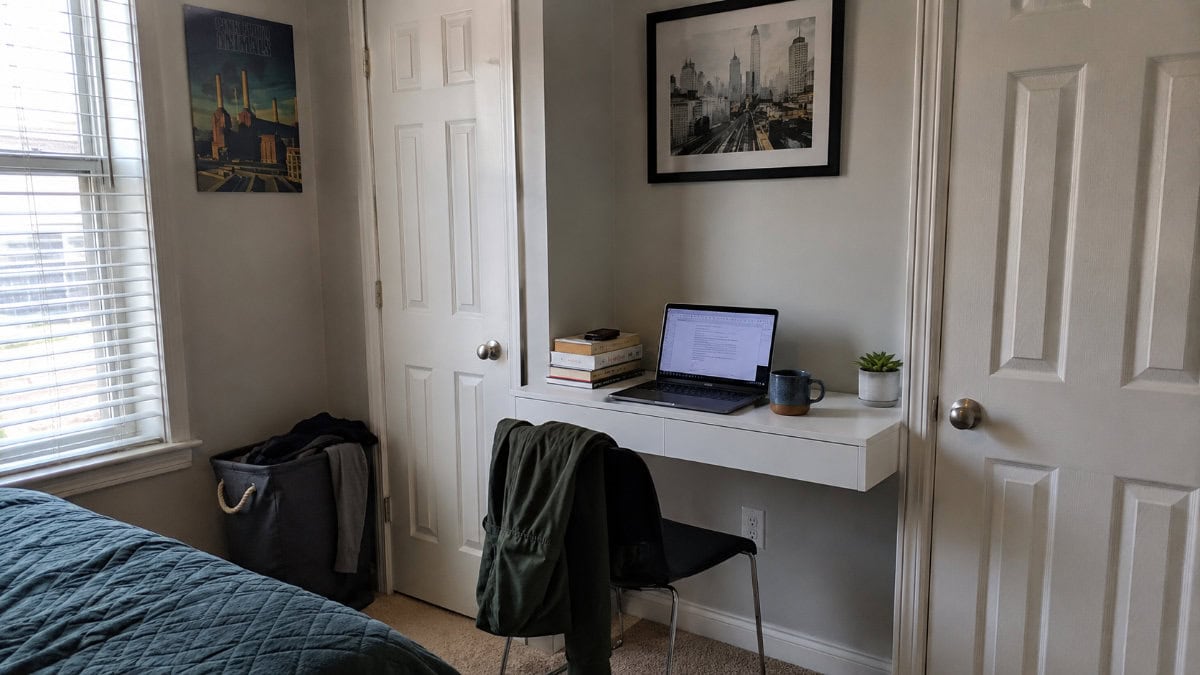 small bedroom desk ideas – narrow floating wall desk mounted between closets with laptop and succulent